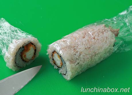 Cutting the fried shrimp sushi roll